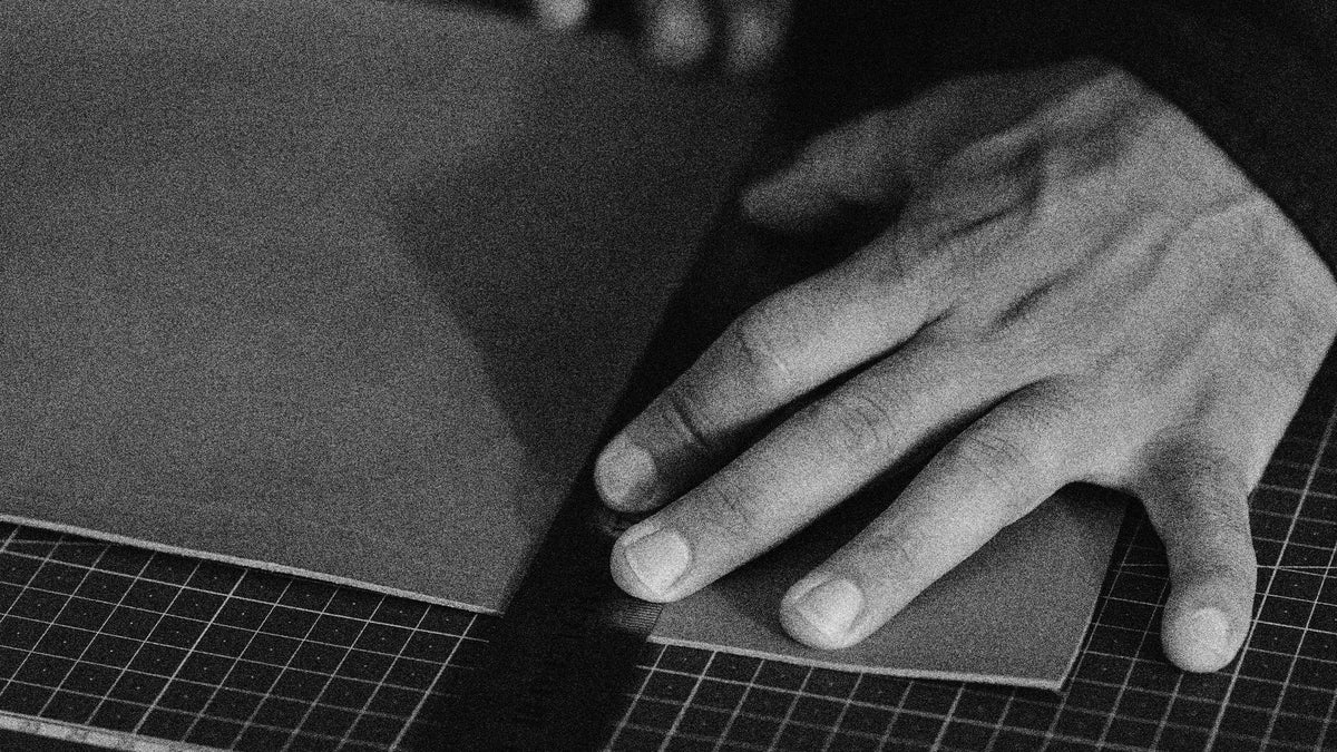 Hands working with a sheet of leather